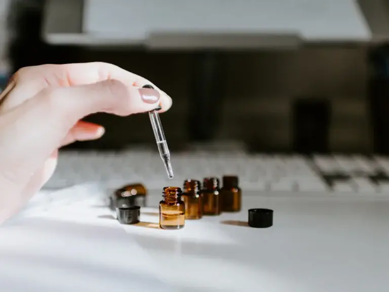 Essential oil dropper over amber bottles – aromatherapy essential oils for wellness products