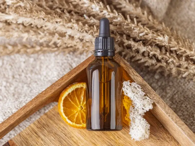 Amber oil bottle with orange slice – fresh and energising citrus ingredients for wellness