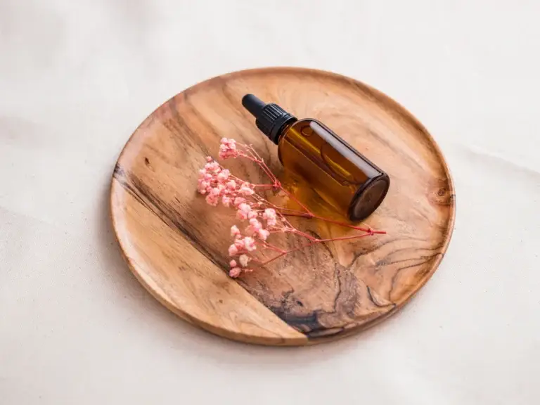 Woody aroma chemicals – amber glass oil bottle on wooden tray for cosmetic formulation